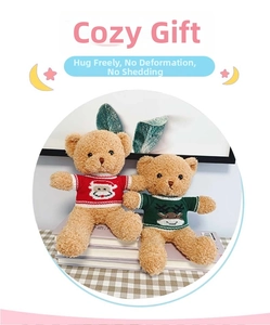 Detail of plush teddy bears in red and green holiday sweaters with festive elk patterns