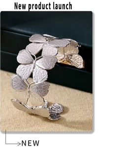 Detailed view of silver butterfly open cuff bracelet with textured wings on a jewelry box