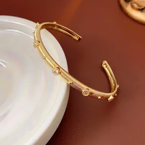 Elegant gold plated ribbed open cuff bracelet with sparkling crystal petal accents