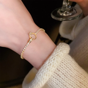 Detailed view of a gold-plated bamboo link bracelet with zircon inlay on a female wrist