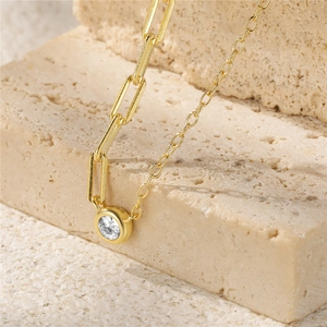 Detail of S925 silver gold necklace with mixed link chain and round zircon pendant