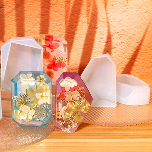 Macro shot of geometric resin molds with botanical dried flower faceted crystal prisms
