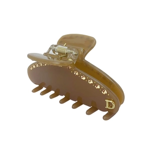 Dettaglio molletta per capelli ambra in acetato con lettera D dorata e strass