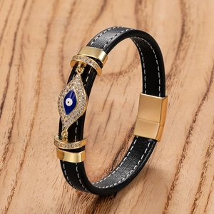 Dettaglio del bracciale punk in pelle nera con chiusura magnetica oro e occhio blu