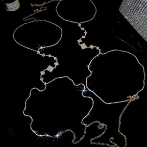 Detailed macro view of luxury silver and gold layered body chains with zircon accents
