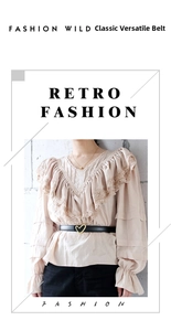 Detail of a thin black leather belt with a gold heart buckle on a lace dress