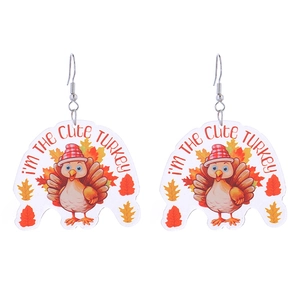 Detail of acrylic turkey earrings with maple leaf patterns and cute festive text