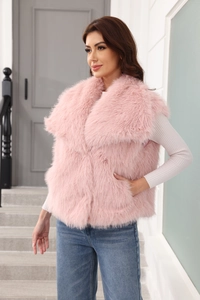 Detail der rosa Kunstfellweste kombiniert mit Strickpullover und blauer Jeans