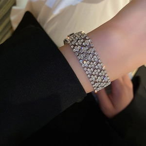 Detailed view of luxury four-row rhinestone bracelet with silver alloy base on wrist