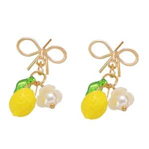 Golden bow earrings with lemon charms and white pearl flowers on a clean white background
