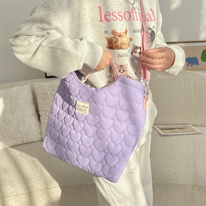 Détail du sac cabas matelassé à cœurs violets avec bandoulière rose et étiquette