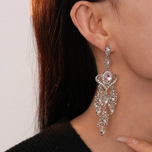 Orecchini a cuore con nappe, pietre rosa e strass argentati indossati dalla modella