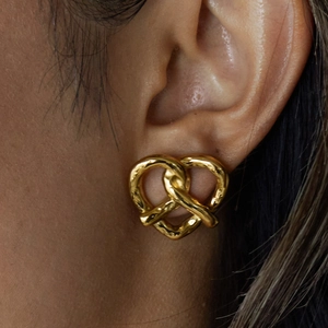 Classic 18K gold-plated stainless steel heart pretzel earrings worn by a model