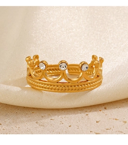Gros plan détaillé d'une bague couronne dorée avec trois zircons sur du satin