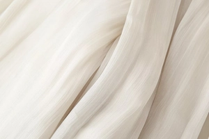 Dettaglio macro del tessuto strutturato bianco crema con pieghe eleganti e drappeggio