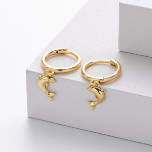 Detailed close-up of golden dolphin charms on polished huggie hoop earrings for women