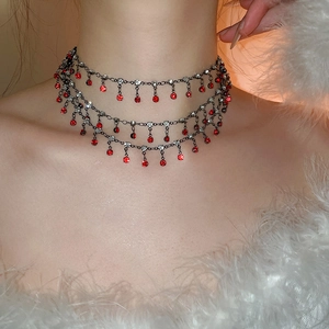 Close-up of double-layer choker with red and white rhinestone tassels on a model