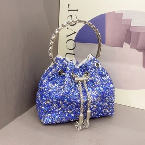 Detail of blue rhinestone bucket bag with crystal metal ring handle and chain tassel