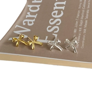 Minimalist irregular ribbon bow stud earrings in gold and silver finish with metallic texture