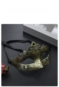 Close-up of vintage bronze half-face mask with intricate hollow patterns and silk ribbons