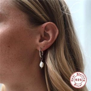 Elegant getragener Sterling-Silber Ohrring mit weißer Perle an einem Modell