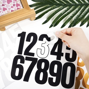 Hand peeling black 3-inch vinyl mailbox number sticker from its backing on white background