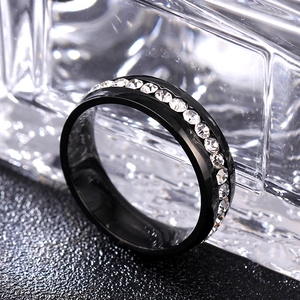 Detail shot of black 6mm ring with sparkling clear stones on a textured dark surface