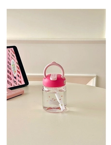 Detail of pink lid with carry handle and white straw on portable glass bottle