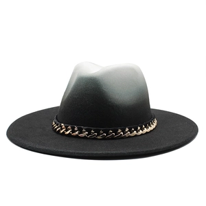 Detail of black and white gradient felt fedora hat featuring a gold chain decoration