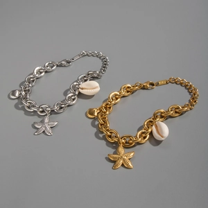 Detail of ocean-themed chunky chain bracelet featuring starfish and shell charms in gold and silver