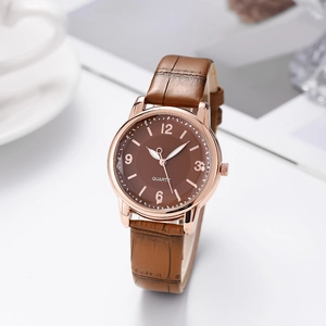 Detailed macro view of a stylish quartz watch with brown leather strap and rose gold case