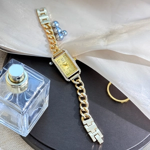 Detailed close-up of a gold chain strap women's watch with a rectangular rhinestone bezel