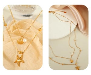 Macro detail of 18K gold plated double layer necklace with starfish and shell charms