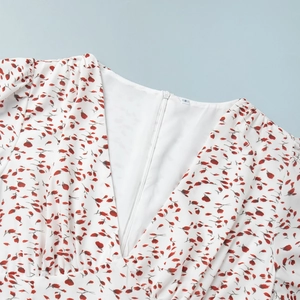 Détail d'une robe blanche à fleurs avec col en V, zip invisible et étiquette de taille S
