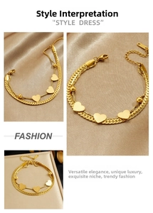 Detail of gold double-layered woven chain bracelet with smooth heart charms and lobster clasp