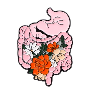 Detail of pink stomach and intestines enamel pin with floral motifs and metal finish