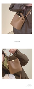 Detail view of the brown PU leather bucket bag featuring gold hardware and logo engraving
