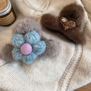 Close-up of plush faux fur hair claws with knit flower and leopard heart details