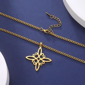Detail of golden stainless steel witch's knot pendant necklace on blue background