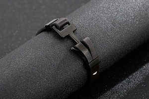 Gros plan du fermoir ancre noir mat sur bracelet en cuir tressé marron pour hommes