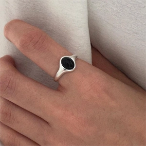 Close-up of minimalist S925 silver ring with oval black onyx gemstone on hand