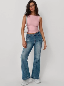 Top rosa senza maniche aderente con jeans blu a zampa e borsa a tracolla bianca