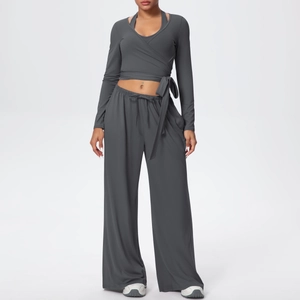 Détail du haut cache-cœur et du pantalon large de l'ensemble de yoga gris foncé 3 pièces