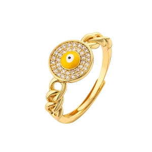 Macro shot of gold chain ring featuring a yellow evil eye motif with sparkling zircon stones