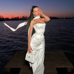 Dettaglio dell'abito lungo in raso bianco con sciarpa coordinata sul lago al tramonto