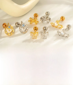 Macro detail of zircon bow and celestial cartilage studs with steel screw ball backs