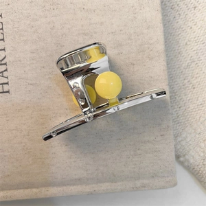 Elegant silver metal hair claw with a yellow pearl and sparkling rhinestones