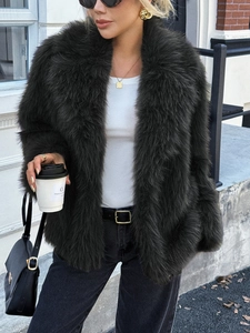 Giacca da donna in ecopelliccia verde scuro con jeans e occhiali da sole per l'autunno