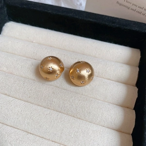 Macro detail of 18k gold plated brushed stud earring with sparkling star-set zirconias