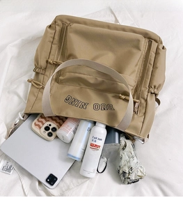 Detail showing the large capacity of the khaki nylon bag with daily items inside